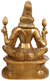 Brass Lakshmi idol from behind, seated cross-legged on round lotus base