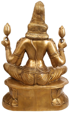 Brass Lakshmi idol from behind, seated cross-legged on round lotus base