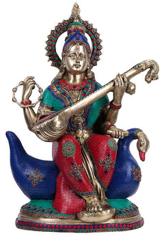 Brass Saraswati seated on a blue swan, four-armed pose with colorful fabric detailing
