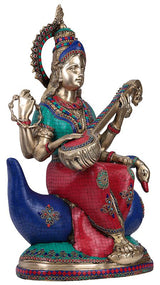 Saraswati goddess brass statue on swan with teal, red, and blue painted panels and ornaments