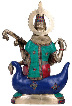 Rear view of brass Saraswati idol on swan, colorful inset panels and raised arms
