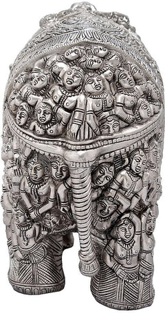 Silver brass elephant statue close-up with clustered carved faces and figures