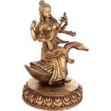 Brass Saraswati idol with raised hand and staff, seated on lotus base