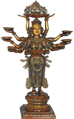 Antique brass-toned ten-armed goddess statue with oil lamps and detailed robe.