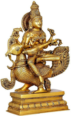 Gold brass Saraswati statue seated on peacock, holding a veena with detailed ornaments