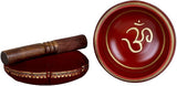Red brass singing bowl with OM symbol on interior, with wooden mallet