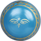 Blue singing bowl bottom with gold face motif and decorative border; brass
