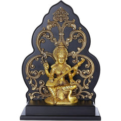 Brass Saraswati statue seated on kirtimukha pedestal, holding a veena, gold finish