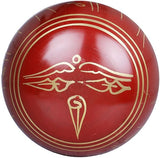 Red Tibetan singing bowl with gold-lined rim and center emblem