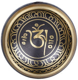 Tibetan singing bowl top view with gold OM symbol and ornate border