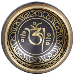 Tibetan singing bowl top view with gold OM symbol and ornate border