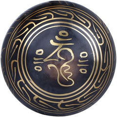 Singing bowl close-up: gold OM design on dark brass