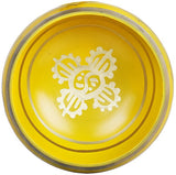 Top view of brass Tibetan singing bowl with centered white Buddhist emblem