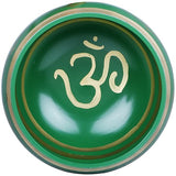 Close-up of green Tibetan singing bowl interior with gold OM marking