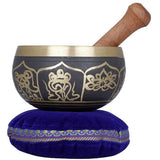Golden and black brass singing bowl with wooden handle, on blue cushion (6 cm height)