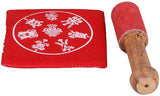 Red cushion with white lotus design and wooden mallet for singing bowl