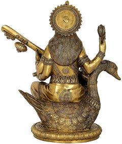 Back view of brass Saraswati statue with veena, ornate halo and patterned base