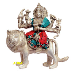 Durga figurine on lion, arms raised; turquoise and red mosaic-style outfit