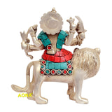 Durga figurine on lion, back view; turquoise top, red skirt, jewel accents
